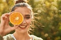 Beautiful brunette woman smiling happy with half orange over eye Royalty Free Stock Photo