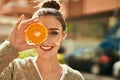 Beautiful brunette woman smiling happy with half orange over eye Royalty Free Stock Photo