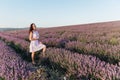 beautiful brunette woman standing in lavender purple flowers walk trip