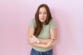 Beautiful brunette woman standing over pink background shaking and freezing for winter cold with sad and shock expression on face Royalty Free Stock Photo