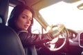 Beautiful brunette woman steers car expensive car Royalty Free Stock Photo