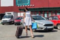 Beautiful brunette woman with suitcase and shopping bags Royalty Free Stock Photo