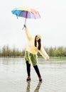 Beautiful brunette woman holding colorful umbrella out in the rain Royalty Free Stock Photo