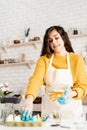 Woman coloring easter eggs blue in the kitchen Royalty Free Stock Photo