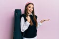 Beautiful brunette young musician woman wearing guitar case celebrating achievement with happy smile and winner expression with Royalty Free Stock Photo