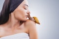 Beautiful young woman kissing giant Achatina snail on light background