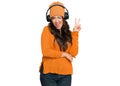 Beautiful brunette young woman listening to music using headphones smiling with happy face winking at the camera doing victory Royalty Free Stock Photo