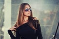 Beautiful brunette young woman in nice black dress, sunglasses. Posing on urban background. Fashion Photo Royalty Free Stock Photo