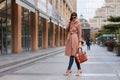 Beautiful brunette young woman in nice brown beige coat, jeans and sunglasses. High heels shoes. Sping fashion photo on urban Royalty Free Stock Photo