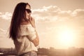 Beautiful brunette young woman posing above sunset city background Royalty Free Stock Photo