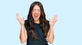 Beautiful brunette young woman wearing black shirt celebrating mad and crazy for success with arms raised and closed eyes Royalty Free Stock Photo