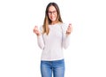 Beautiful brunette young woman wearing casual white sweater and glasses doing money gesture with hands, asking for salary payment, Royalty Free Stock Photo