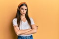 Beautiful brunette young woman wearing casual white t shirt skeptic and nervous, disapproving expression on face with crossed arms Royalty Free Stock Photo