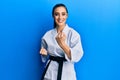 Beautiful brunette young woman wearing karate fighter uniform with black belt doing attack pose smiling with a happy and cool Royalty Free Stock Photo