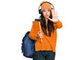 Beautiful brunette young woman wearing student backpack and holding books with open hand doing stop sign with serious and Royalty Free Stock Photo