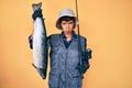 Beautiful brunettte fisher woman holding fishing rod and raw salmon depressed and worry for distress, crying angry and afraid Royalty Free Stock Photo