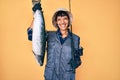 Beautiful brunettte fisher woman holding fishing rod and raw salmon smiling with a happy and cool smile on face Royalty Free Stock Photo