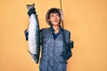 Beautiful brunettte fisher woman holding fishing rod and raw salmon smiling looking to the side and staring away thinking Royalty Free Stock Photo