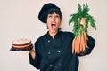 Beautiful brunettte woman chef cooking carrot cake angry and mad screaming frustrated and furious, shouting with anger looking up Royalty Free Stock Photo