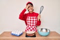 Beautiful brunettte woman cooking cake using baker whisk stressed and frustrated with hand on head, surprised and angry face Royalty Free Stock Photo