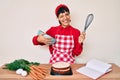 Beautiful brunettte woman cooking carrot cake using whisk winking looking at the camera with sexy expression, cheerful and happy Royalty Free Stock Photo