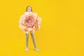 Beautiful bud. Cute girl holding a huge peony flower in her hands on a yellow background Royalty Free Stock Photo