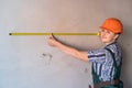 Beautiful builder with measuring tape in new apartment