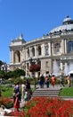 beautiful building admired by people, fountain and flowers around, local landmark