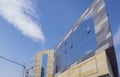 Beautiful building under construction in the form of the bow of the ship against the blue sky. The cloud above the building looks Royalty Free Stock Photo