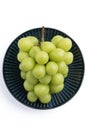 Beautiful a bunch of Shine Muscat green grape on a blue plate isolated on white background Royalty Free Stock Photo