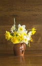 Beautiful bunch of yellow and white daffodils in rustic jug on vintage wooden background. Royalty Free Stock Photo