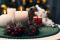 Beautiful burning candles and Christmas decor on white table against festive lights. Space for text Royalty Free Stock Photo