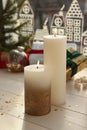 Beautiful burning candles with Christmas decor on white wooden table near window Royalty Free Stock Photo