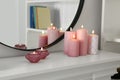 Beautiful burning candles on white console table near mirror indoors Royalty Free Stock Photo