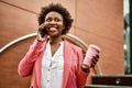 Beautiful business african american woman with afro hair smiling happy and confident outdoors at the city having a conversation Royalty Free Stock Photo