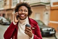 Beautiful business african american woman with afro hair smiling happy and confident outdoors at the city having a conversation Royalty Free Stock Photo