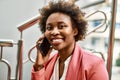 Beautiful business african american woman with afro hair smiling happy and confident outdoors at the city having a conversation Royalty Free Stock Photo