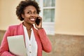 Beautiful business african american woman with afro hair smiling happy and confident outdoors at the city having a conversation Royalty Free Stock Photo