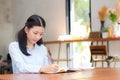 Beautiful business asian young woman writing on notebook on table. Royalty Free Stock Photo