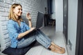 Beautiful business lady in casual is using a laptop and smiling while sitting on the floor at home and working Royalty Free Stock Photo