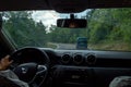 indian young woman driving a car suv in the mountain road a rainy cloudy day