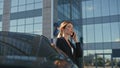 Beautiful business woman calling cell phone near modern office building close up Royalty Free Stock Photo