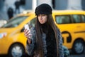 Beautiful business woman calling taxi using mobile phone in the city street