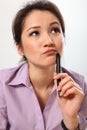 Beautiful business woman deep in thought with pen Royalty Free Stock Photo