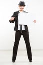 Beautiful business woman with gun olding a blank billboard. Royalty Free Stock Photo