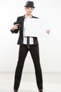 Beautiful business woman with gun olding a blank billboard. Royalty Free Stock Photo