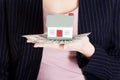 Beautiful business woman holding dollar currency and house. Royalty Free Stock Photo