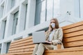 Beautiful business woman in mask talking over the phone and working at laptop Royalty Free Stock Photo