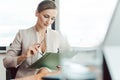 Beautiful business woman reading a file in her office