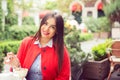 Beautiful business woman in red suit, blue shirt having coffee break in a trendy cafe Royalty Free Stock Photo